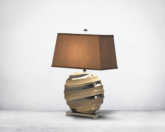 Brown table lamp in ceramic with metal base & translucent fabric shade.