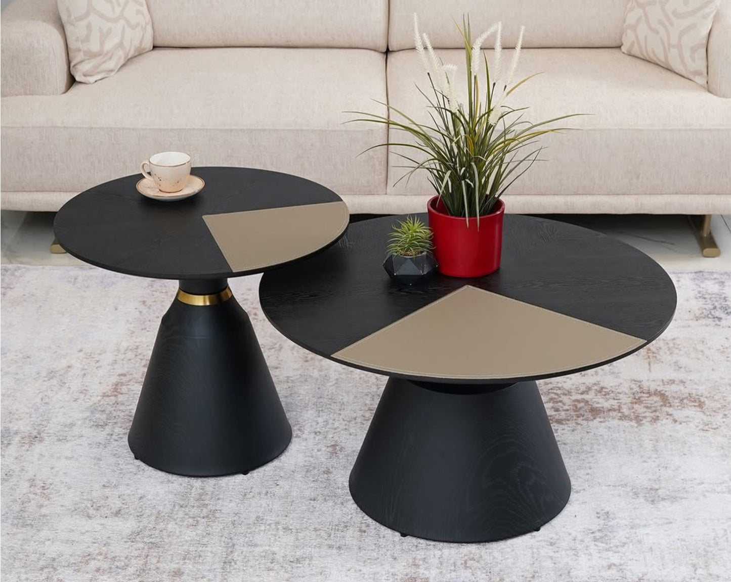 Two modern black and beige coffee tables with decorative items in a living room setting.