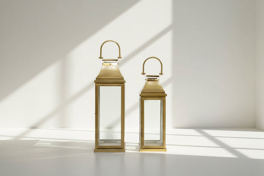 This lantern in modern classic style is crafted in Stainless steel finished in antique gold. It has clear glass & brass handles. This is a perfect mood setter enhancing any room with its glow. 1 large 2 small