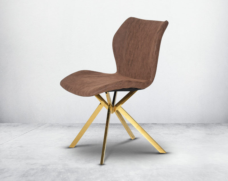 Dining chair upholstered in faux leather with high polished stainless steel legs plated in gold.