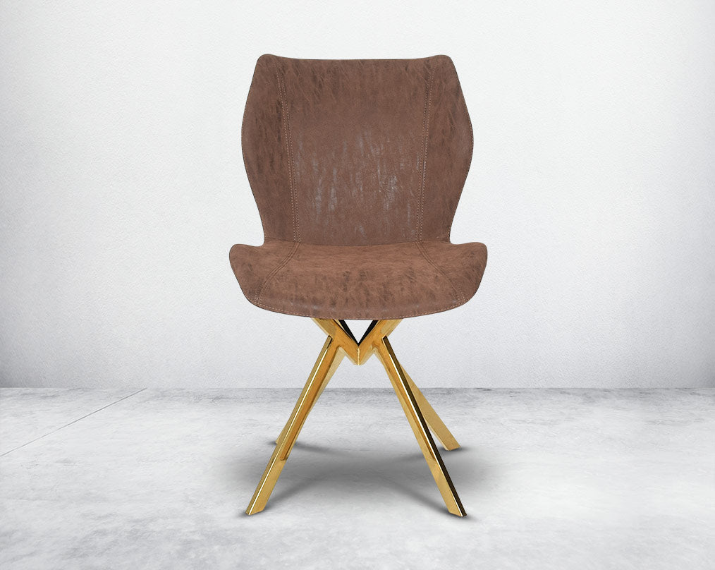 Dining chair upholstered in faux leather with high polished stainless steel legs plated in gold front view