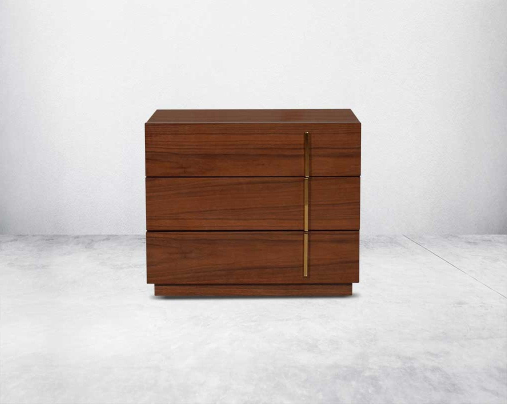 Symmetry and style define this eye-catching bedside table, constructed from light walnut veneer with three drawers & gold-finished stainless steel handles.