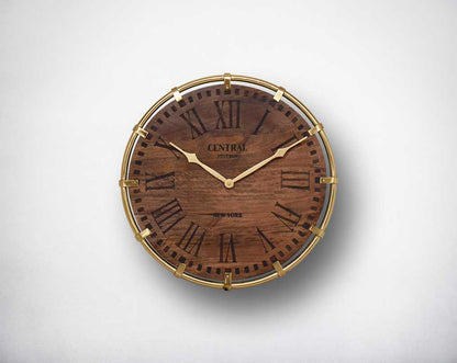 Wall clock in antique matt brass and natural wood finish in Roman numerals.