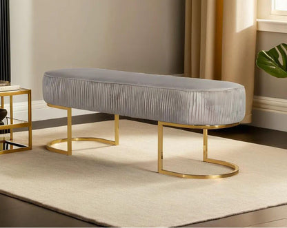 Double bench upholstered with tufted fabric seat and high polished gold plated stainless steel legs in classic design.