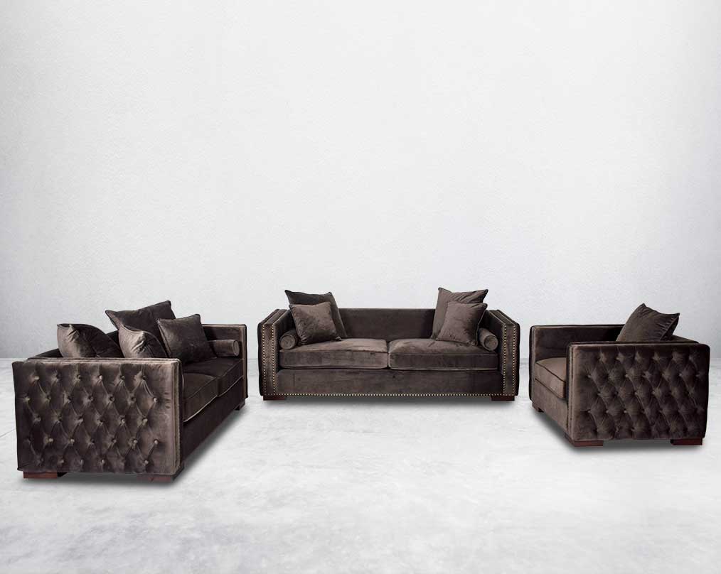 3+2+1 seater sofa set upholstered in fabric with gold rivets on the arms and front and tufted on the sides.