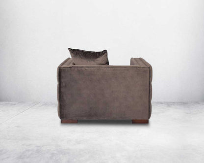 1 seater sofa set upholstered in fabric with gold rivets on the arms and front and tufted on the sides back view