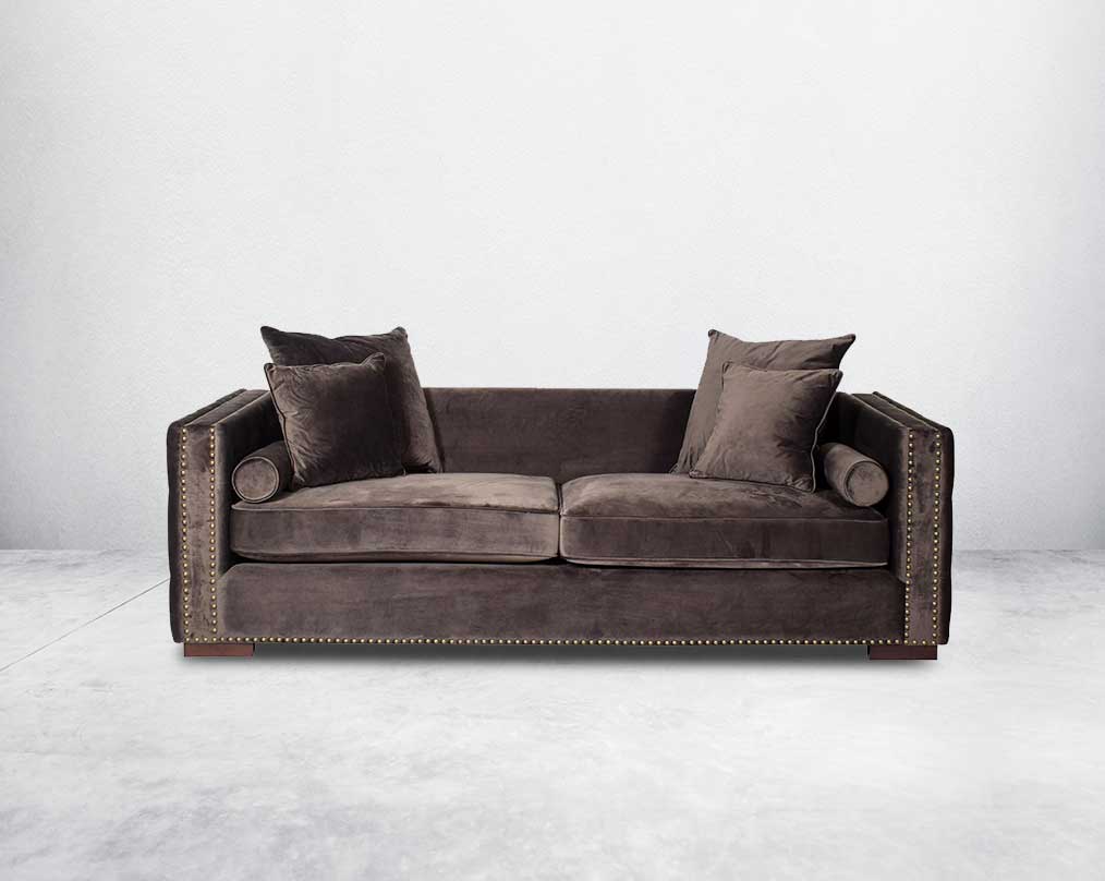 3 seater sofa set upholstered in fabric with gold rivets on the arms and front and tufted on the sides front view