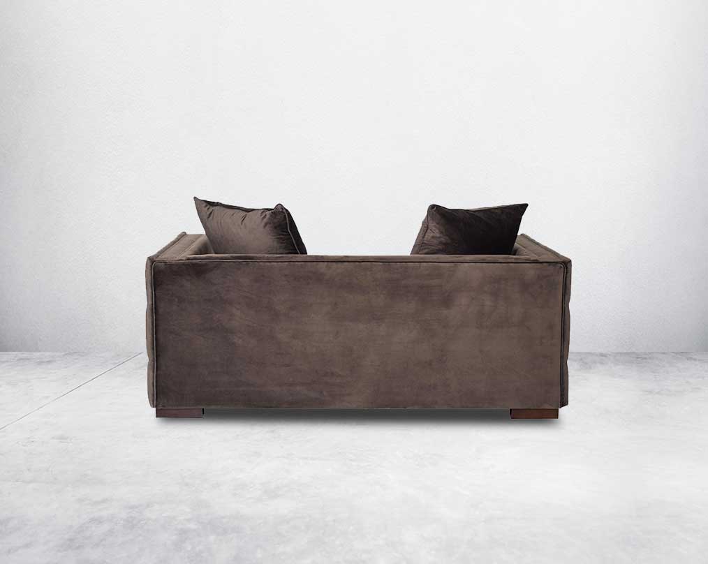 2 seater sofa set upholstered in fabric with gold rivets on the arms and front and tufted on the sides back view