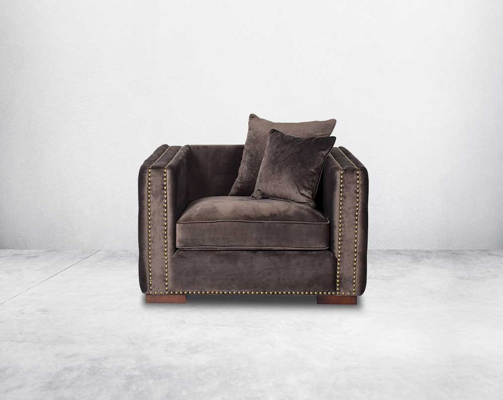 1 seater sofa set upholstered in fabric with gold rivets on the arms and front and tufted on the sides front view