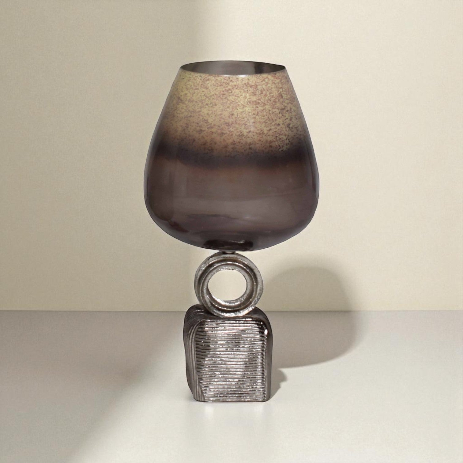 Decorative lamp with textured glass shade and metallic base on a neutral background