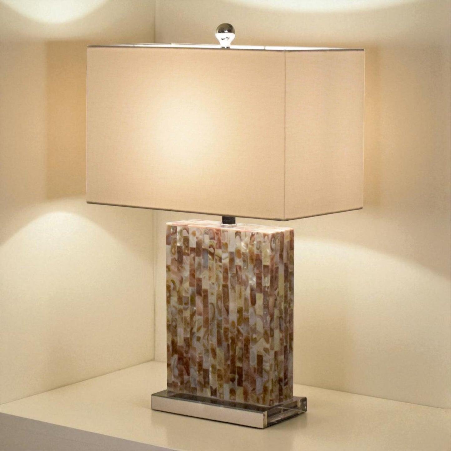 Table lamp with mosaic base and beige rectangular shade on a neutral background