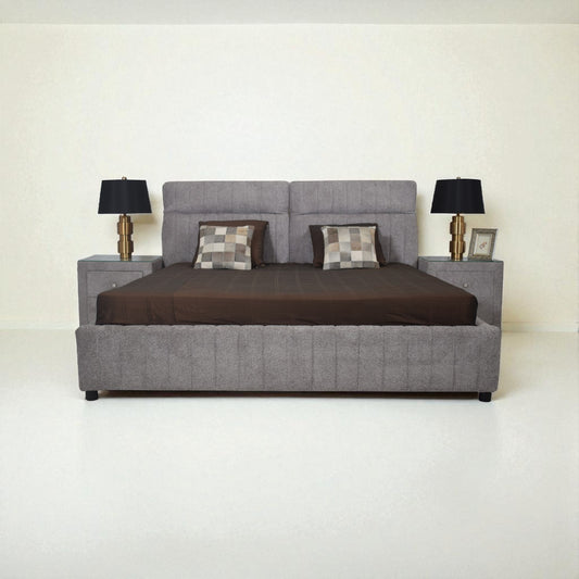 Gray upholstered bed with brown bedding and two lamps on a white background