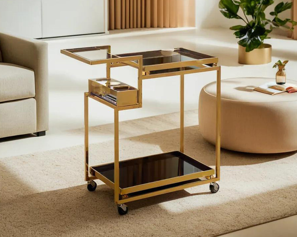 Trolley/dining cart with black glass top and base The body is in stainless steel, gold plated and it is movable with a handle with wheels.