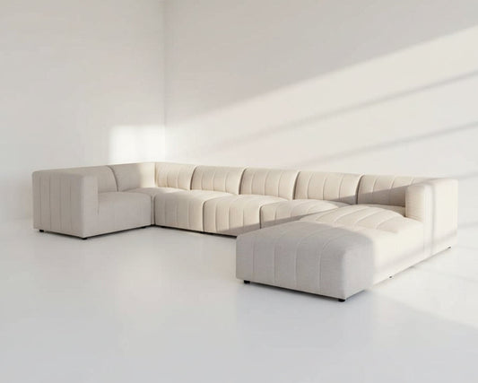 The L shaped modular sofa comes upholstered in regal beige fabric with vertical channel quilting & an ottoman to compliment