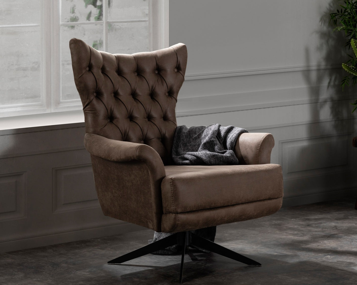 Wing arm chair upholstered in fabric with tufted back and black powder-coated legs in modern classic design.