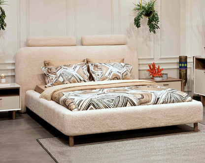 Beige upholstered bed with patterned bedding in a bedroom setting