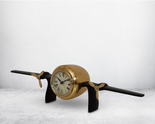 This unique vintage airplane propeller table clock comes with the clock in the center of the wings. This antique clock is made out of brass in antique matt finish. It has a white dial with Roman Numerals for a vintage look. This is a great statement piece