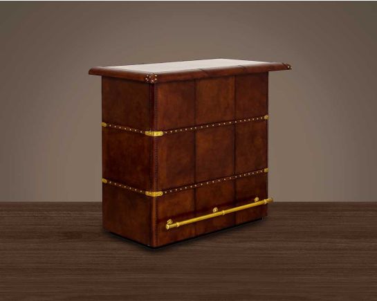 Bar counter in distressed cognac leather with a vintage look with brass hardware and wooden slats.