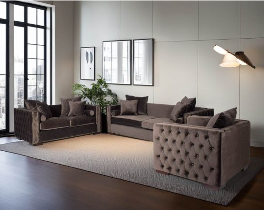 3+2+1 seater sofa set upholstered in fabric with gold rivets on the arms and front and tufted on the sides.